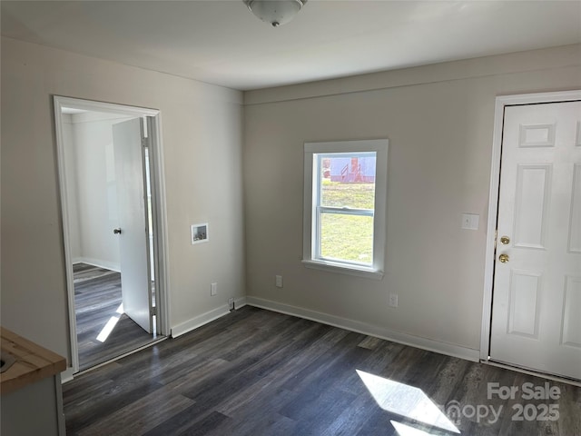 interior space featuring baseboards and dark wood finished floors