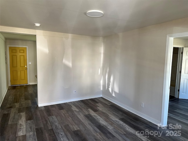 unfurnished room with dark wood-style floors and baseboards