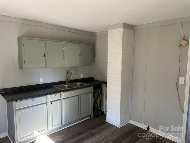 kitchen with dark wood-type flooring, dark countertops, and a sink