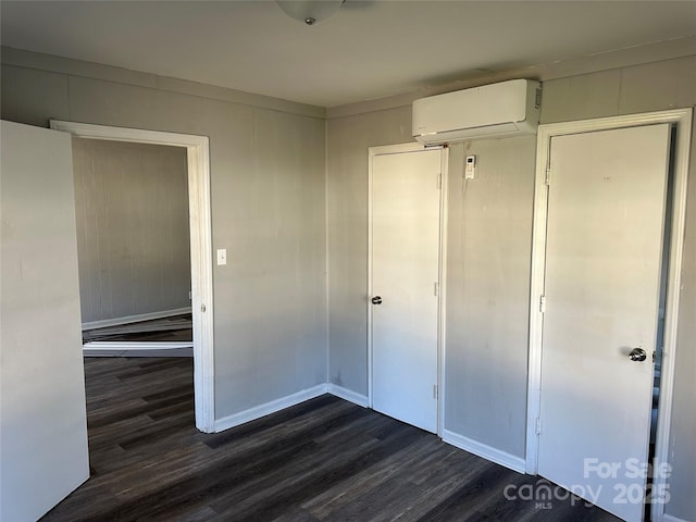 unfurnished bedroom featuring a closet, dark wood-type flooring, and an AC wall unit