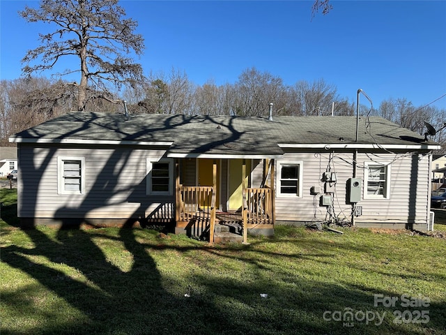 rear view of house featuring a yard