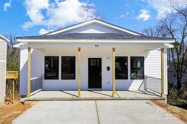 view of front of property with a porch and roof with shingles