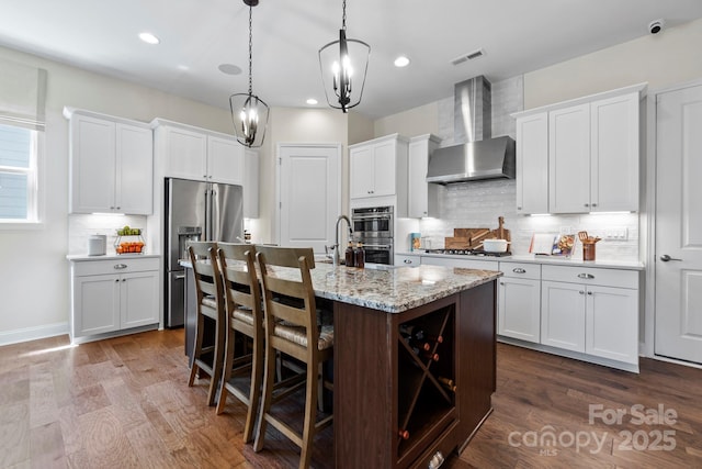 305 Basil Dr, Indian Trail, NC 28079 - kitchen featuring wall chimney range hood, stainless steel appliances, decorative backsplash, dark wood-type flooring, and recessed lighting
