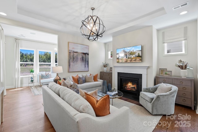 305 Basil Dr, Indian Trail, NC 28079 - living area with a tray ceiling, wood finished floors, a fireplace with flush hearth, and recessed lighting