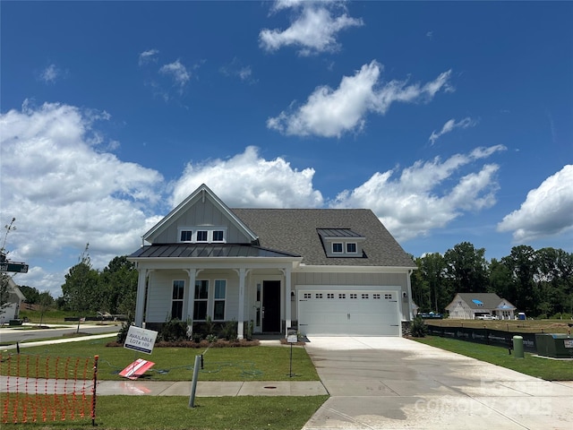 305 Basil Dr, Indian Trail, NC 28079 - view of front of property featuring a front yard, board and batten siding, concrete driveway, a standing seam roof, and a garage