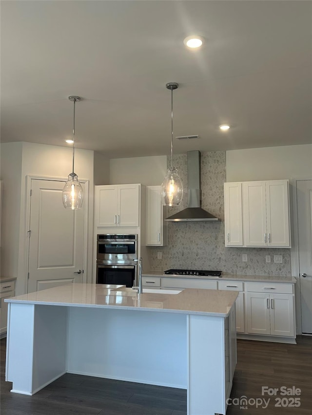305 Basil Dr, Indian Trail, NC 28079 - kitchen featuring wall chimney exhaust hood, gas stovetop, stainless steel double oven, white cabinets, and recessed lighting