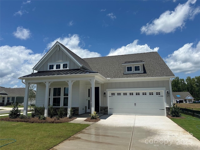 305 Basil Dr, Indian Trail, NC 28079 - view of front of home with board and batten siding, concrete driveway, a standing seam roof, a front lawn, and roof with shingles