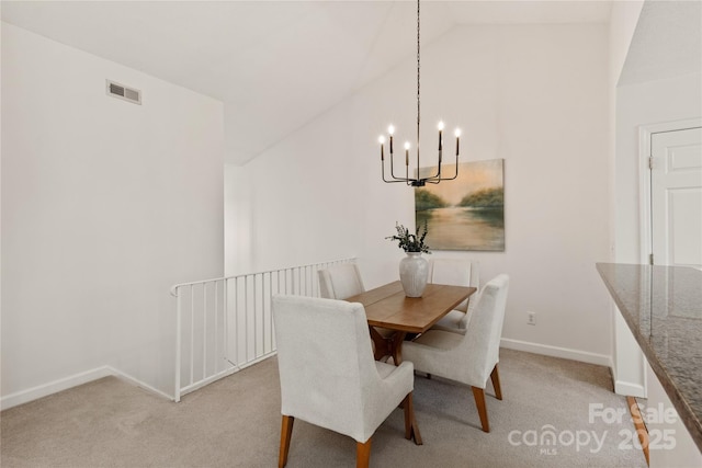 dining room featuring a notable chandelier, light carpet, visible vents, baseboards, and vaulted ceiling