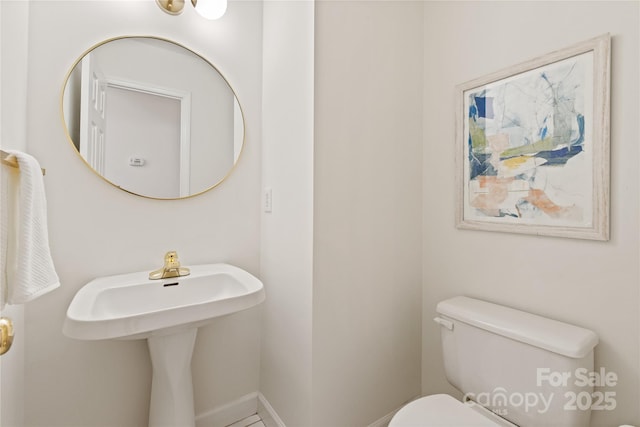 bathroom featuring baseboards and toilet