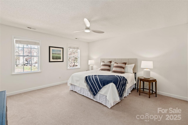 bedroom with carpet, a textured ceiling, visible vents, and baseboards