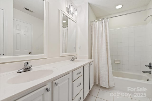 bathroom featuring double vanity, tile patterned flooring, visible vents, and a sink