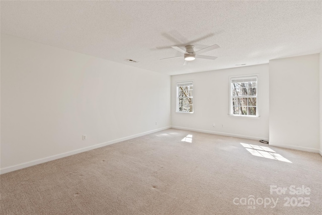 unfurnished room featuring baseboards, carpet, visible vents, and a textured ceiling