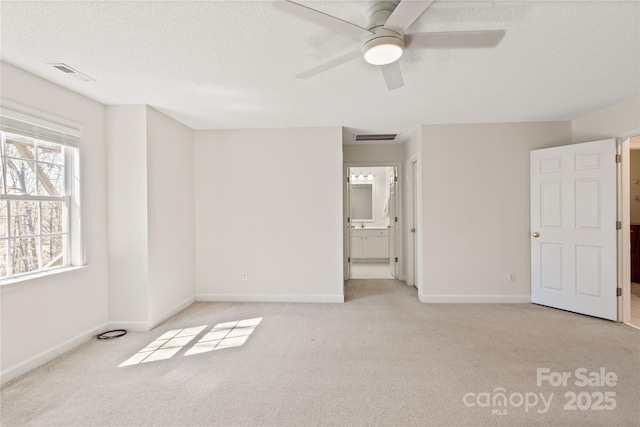 unfurnished bedroom with light carpet, baseboards, visible vents, and a textured ceiling