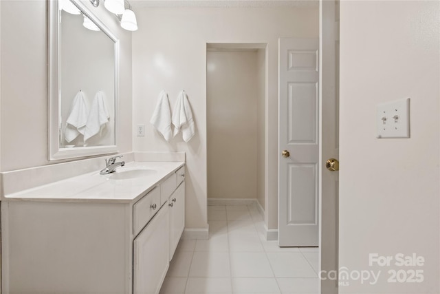 bathroom featuring tile patterned flooring, vanity, and baseboards