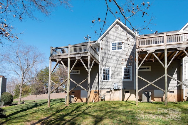 rear view of property with crawl space, a lawn, and a deck