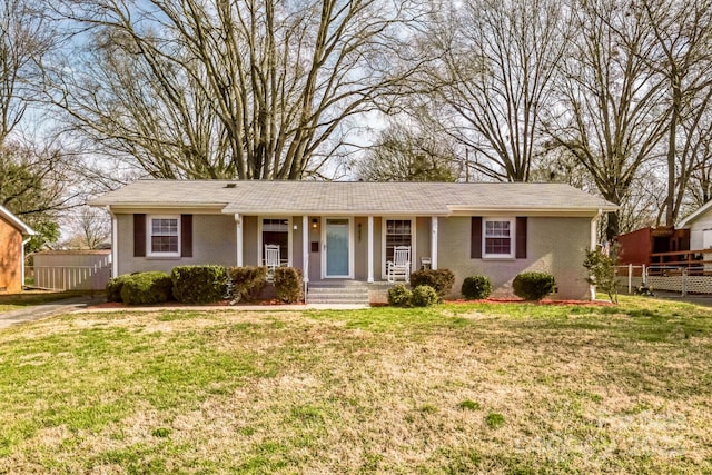 ranch-style house featuring brick siding, a front lawn, and fence