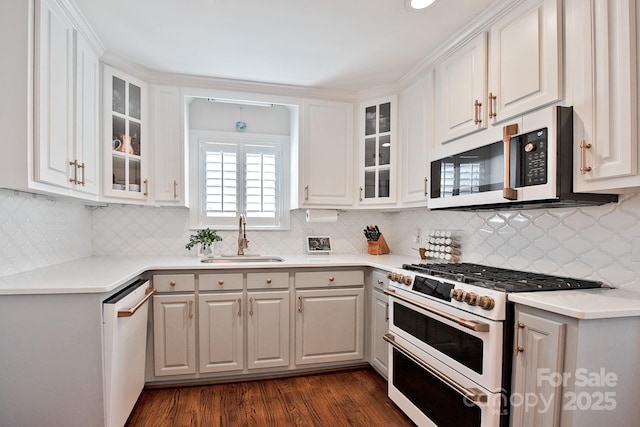 kitchen featuring white appliances, white cabinetry, and a sink