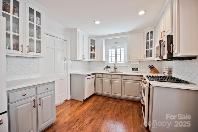 kitchen with dishwasher, dark wood-style floors, stainless steel microwave, double oven range, and a sink