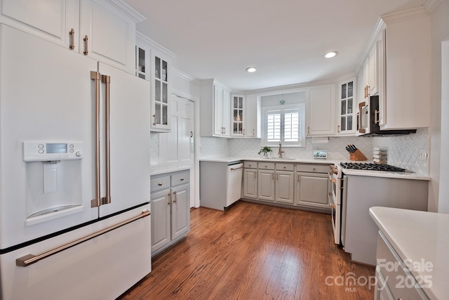 kitchen featuring dark wood-type flooring, white cabinetry, high end appliances, and a sink