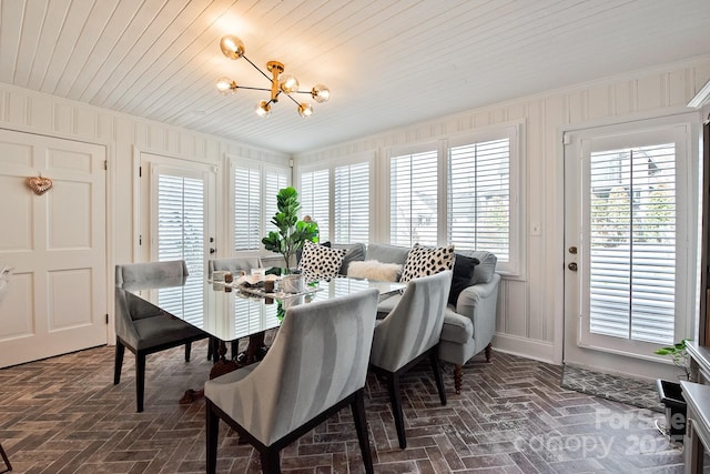 dining room with wood walls, brick floor, wooden ceiling, and an inviting chandelier