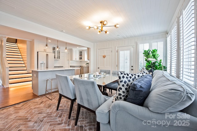 dining room featuring brick floor, wood ceiling, stairway, and a chandelier