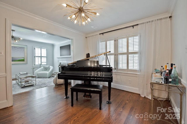 living area with baseboards, a chandelier, crown molding, and wood finished floors