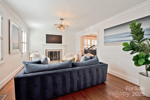 living room with baseboards, a fireplace, ornamental molding, and wood finished floors