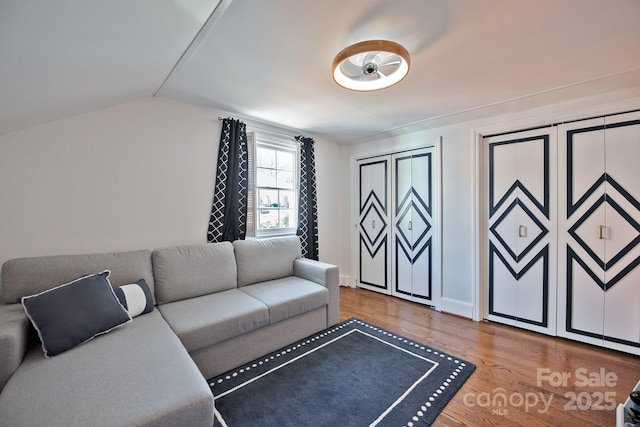 living area featuring lofted ceiling and wood finished floors