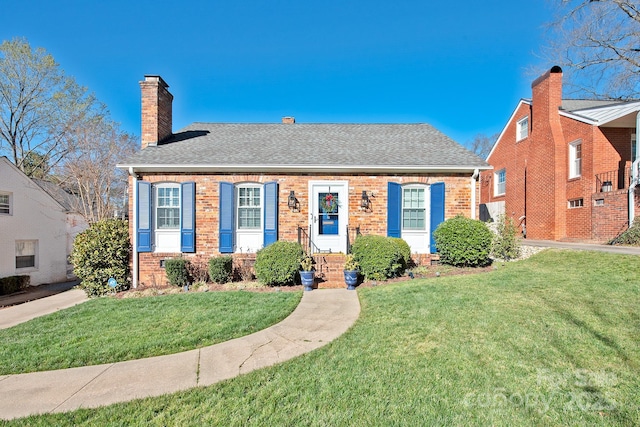 bungalow with a chimney, brick siding, roof with shingles, and a front yard