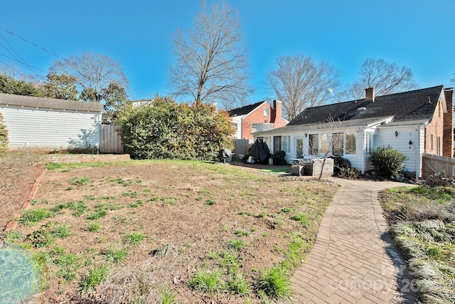 view of yard with fence and an outbuilding