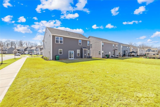 back of house featuring a residential view and a lawn