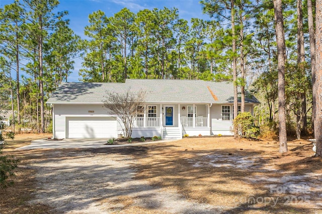 ranch-style house with driveway, covered porch, an attached garage, and roof with shingles