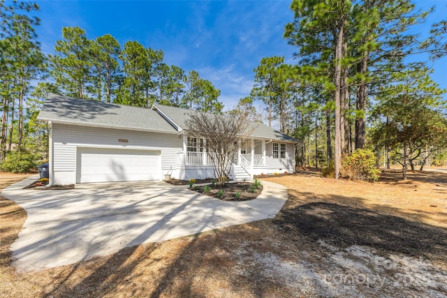 view of front of home featuring an attached garage, a porch, concrete driveway, and roof with shingles