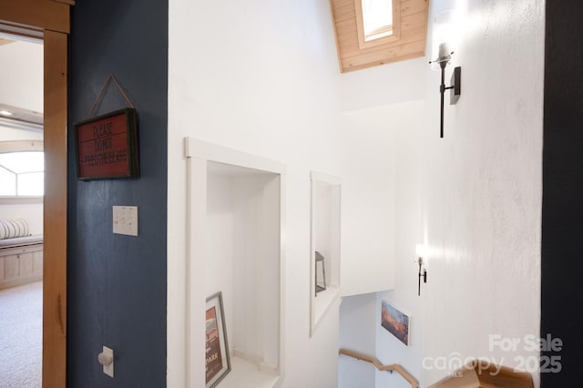 interior space featuring a skylight, carpet flooring, and a high ceiling