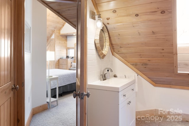 bathroom featuring lofted ceiling, wood ceiling, wooden walls, and vanity