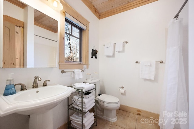 full bathroom featuring wooden ceiling, tile patterned flooring, toilet, a sink, and baseboards