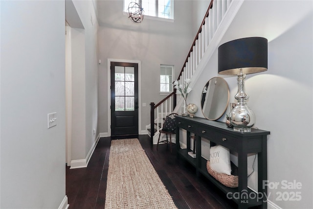 entryway with stairs, dark wood-style floors, and a healthy amount of sunlight