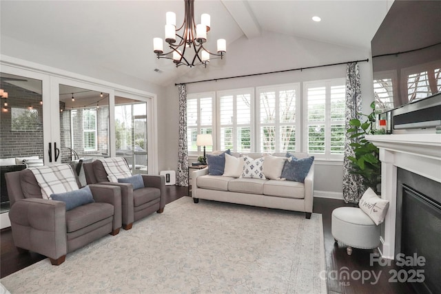 living room featuring baseboards, lofted ceiling with beams, recessed lighting, wood finished floors, and a glass covered fireplace