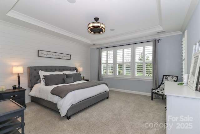 bedroom featuring light colored carpet, baseboards, a tray ceiling, and ornamental molding