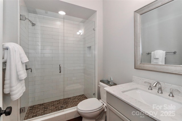 bathroom with vanity, toilet, and a shower stall