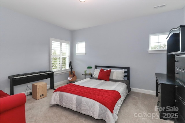 carpeted bedroom with visible vents and baseboards