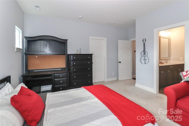 carpeted bedroom featuring visible vents, ensuite bath, baseboards, and a sink