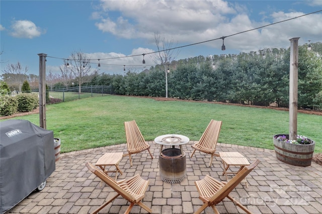 view of patio with fence, a grill, and an outdoor fire pit