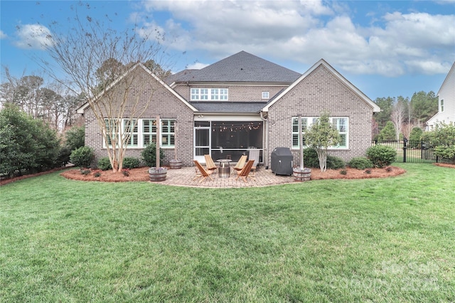 back of property with fence, a lawn, brick siding, and a sunroom