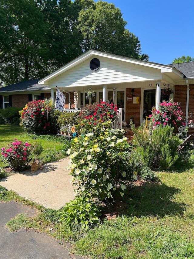 view of front facade with covered porch and brick siding