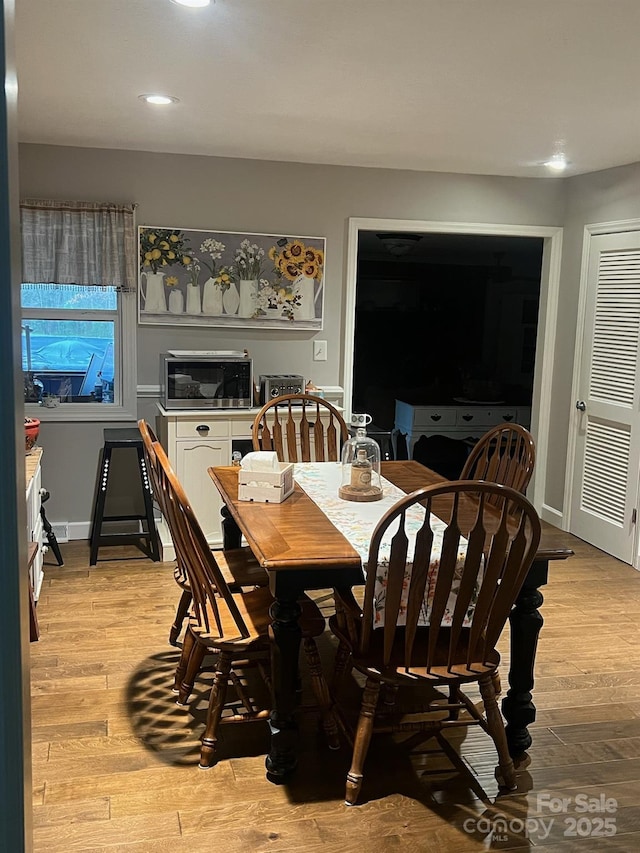 dining area featuring light wood-type flooring and baseboards