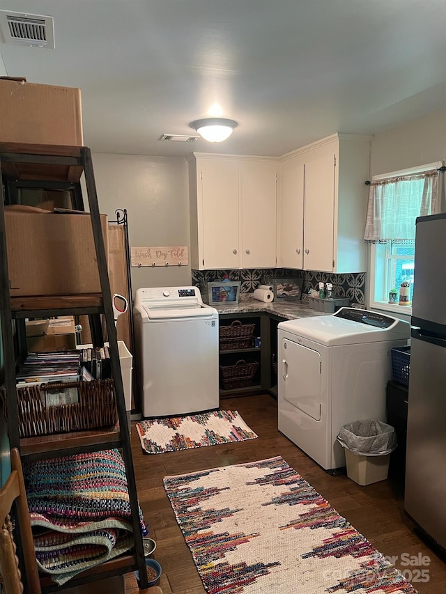 laundry area with cabinet space, dark wood-style floors, visible vents, and separate washer and dryer