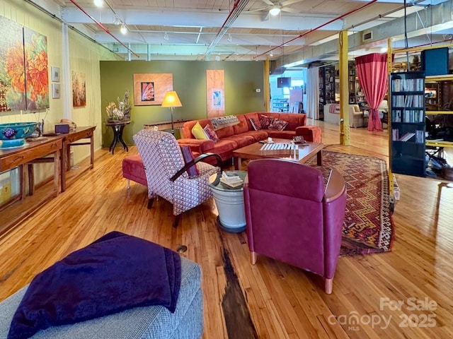 living area featuring beam ceiling and wood-type flooring