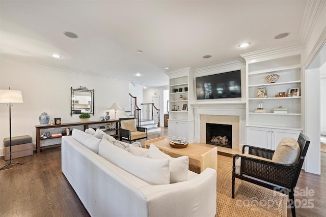 living room with dark wood-style floors, a premium fireplace, stairway, ornamental molding, and recessed lighting