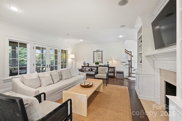 living room featuring stairs, french doors, wood finished floors, and crown molding